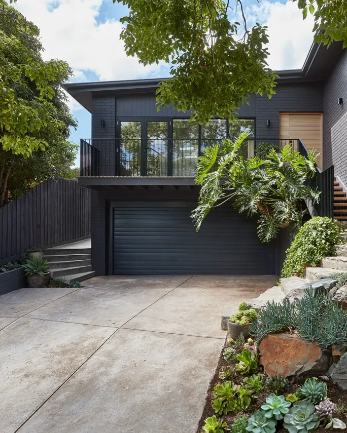 Old concrete driveway of black post-modern house