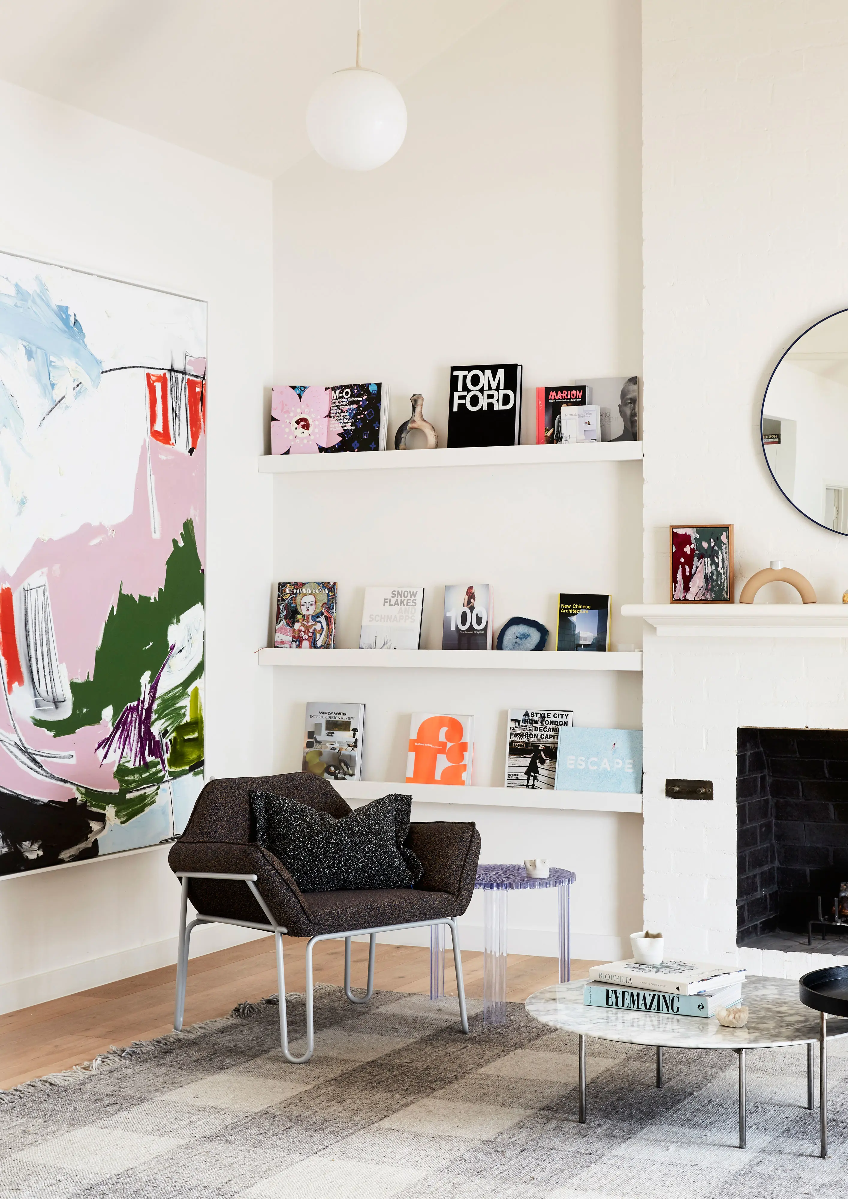 Modern white living room with fireplace and round mirror