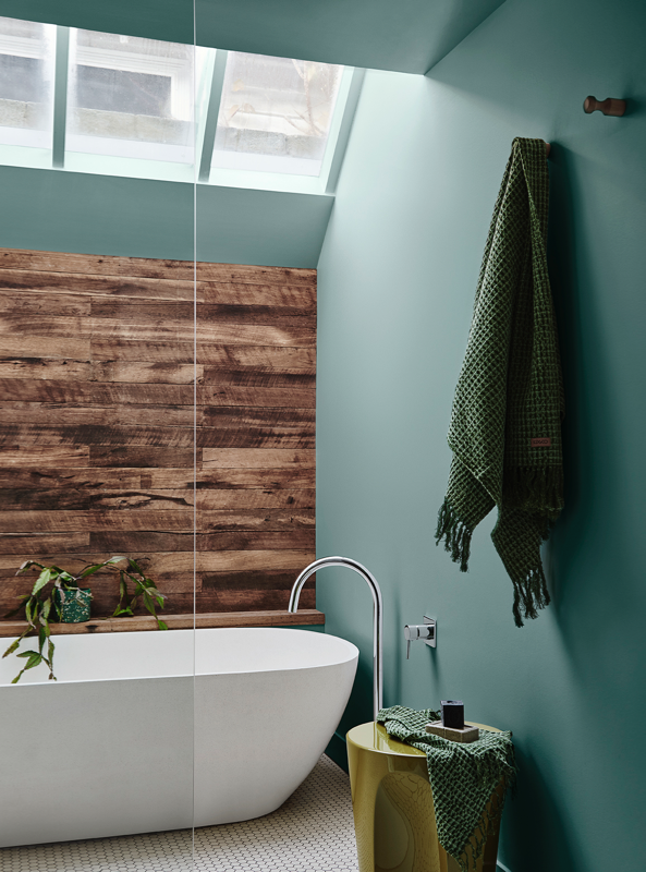 Earthy bathroom with green walls and timber paneling
