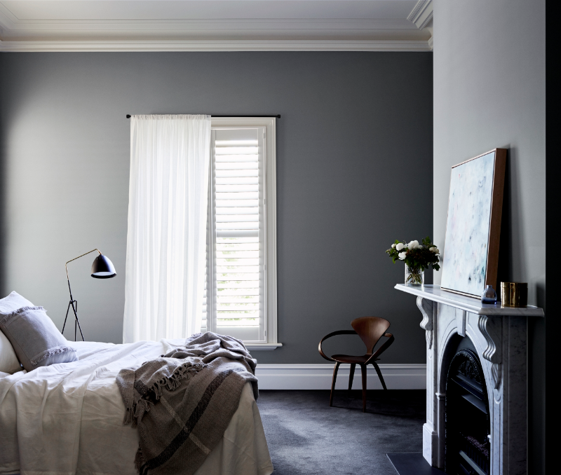 Grey bedroom with white shutters and marble fire place