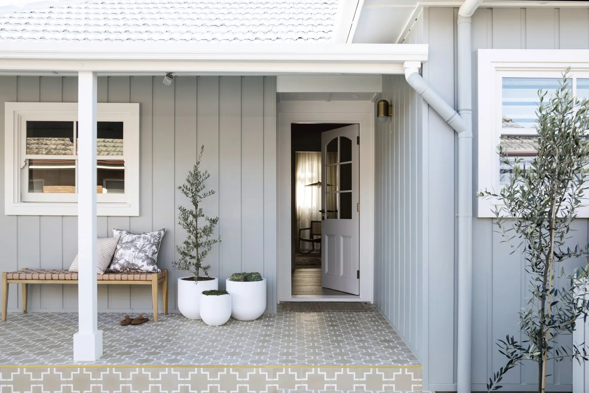 Grey house with white trim verandah and tiled patio