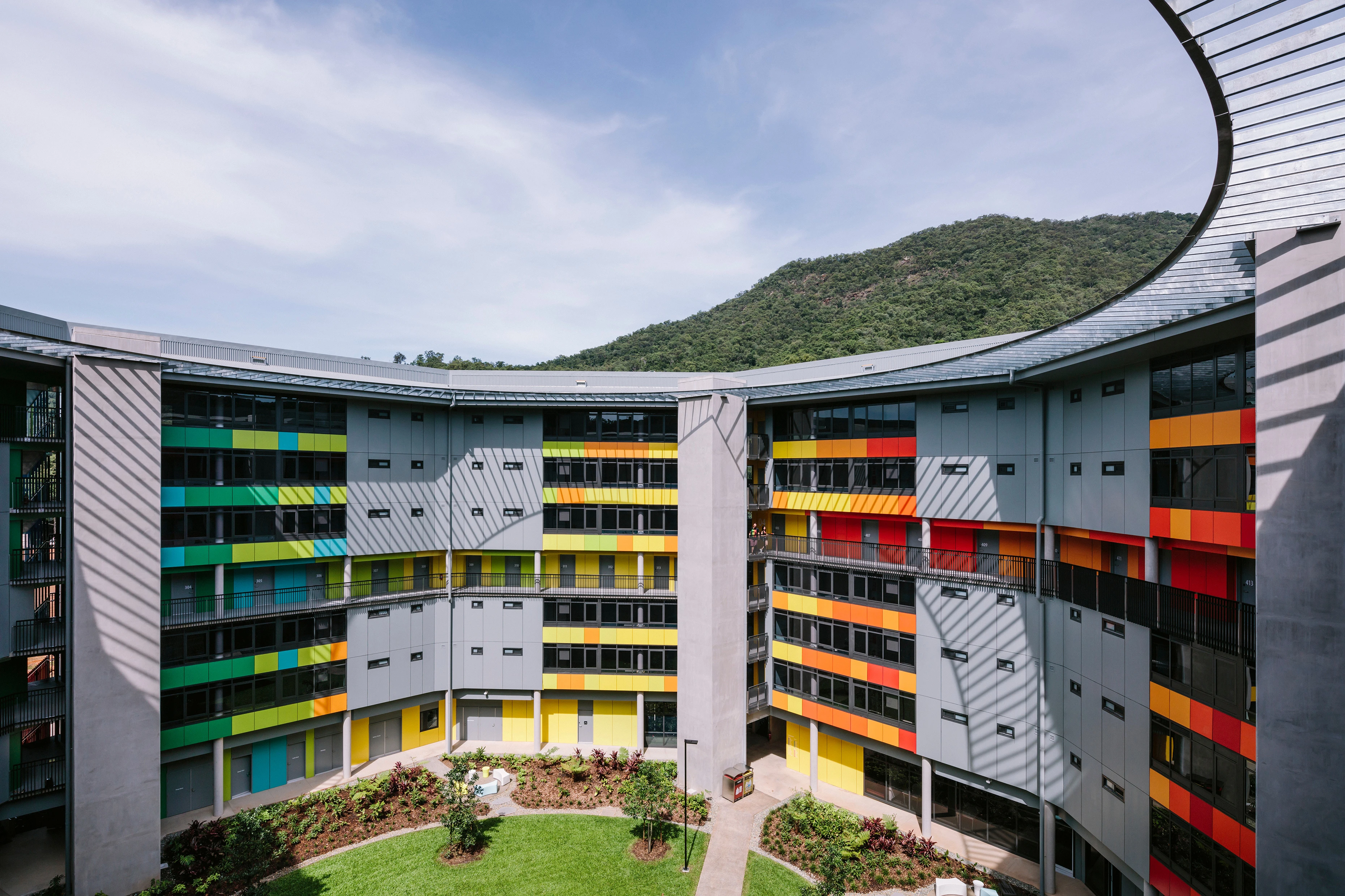 Multi-storey student living quarters with accents of yellow, orange, blue, green and red on walkway walls and balconies