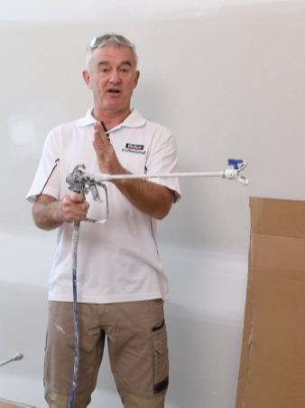 Man holding spray gun with extension