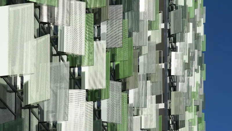 Silver and green metal louvres on multi-storey building
