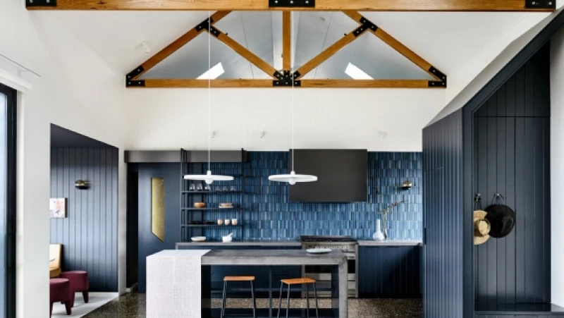 White and blue kitchen with pitched ceiling and exposed beams