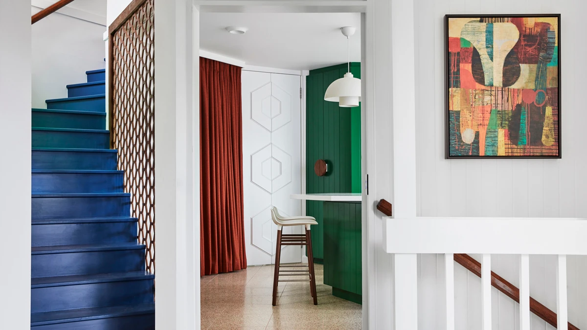Colourful stairs, curtains and cabinetry in the home against white walls
