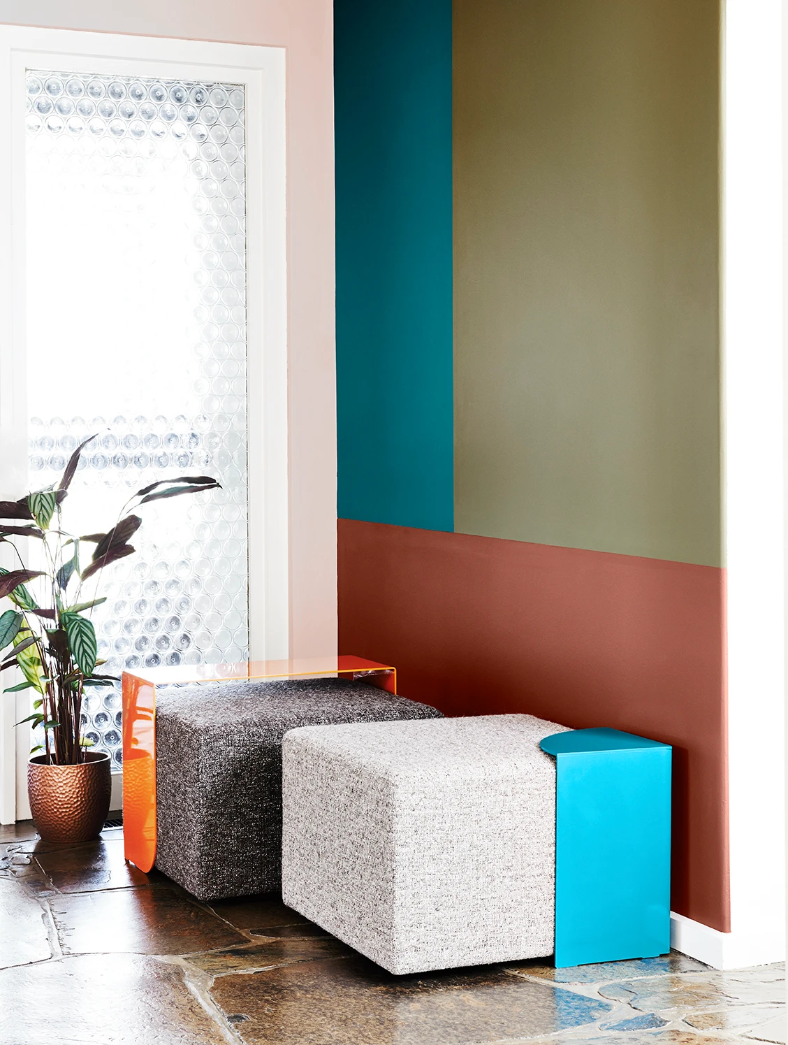 Grey stools against teal, green and brown feature wall.