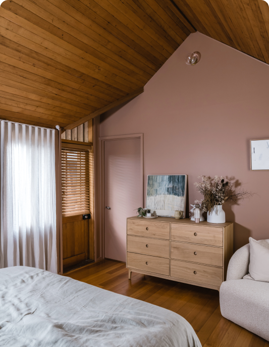 Bedroom with blush pink walls and timber panel ceiling