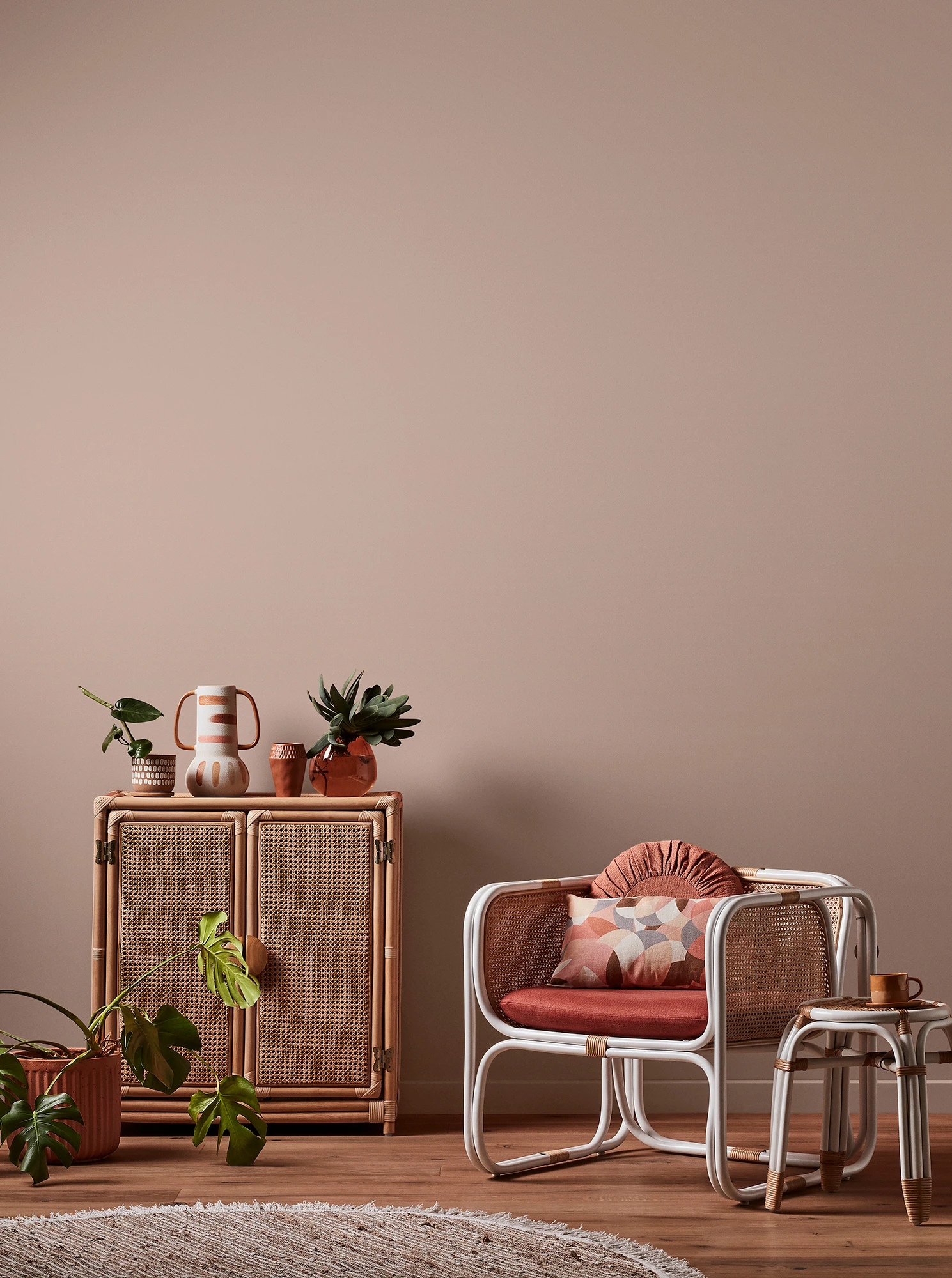 Light brown living room with natural rattan cabinet and white rattan table and chair with pink cushions