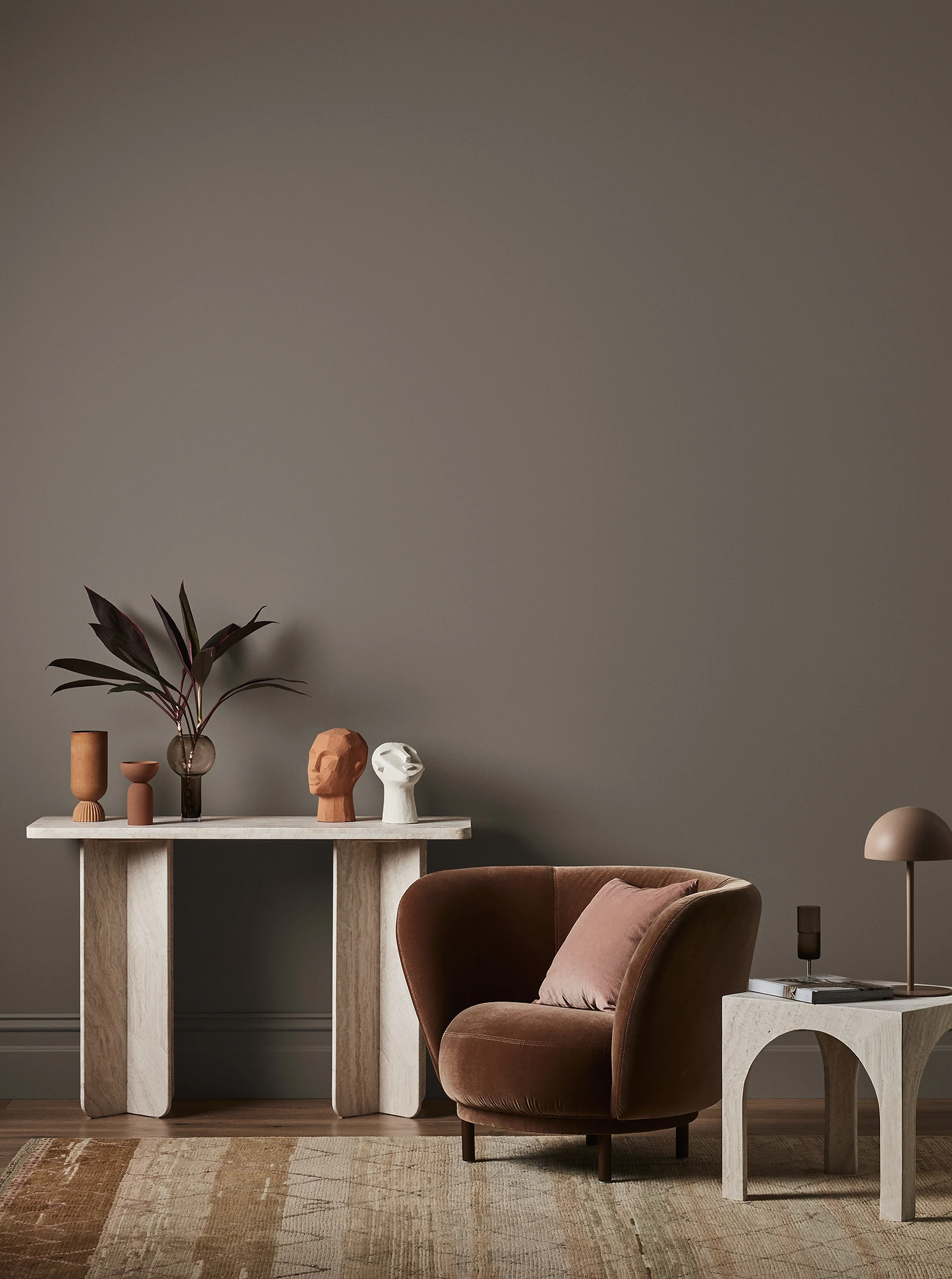 Dulux browns featuring on a wall with arm chair and hallway table with decorative items.