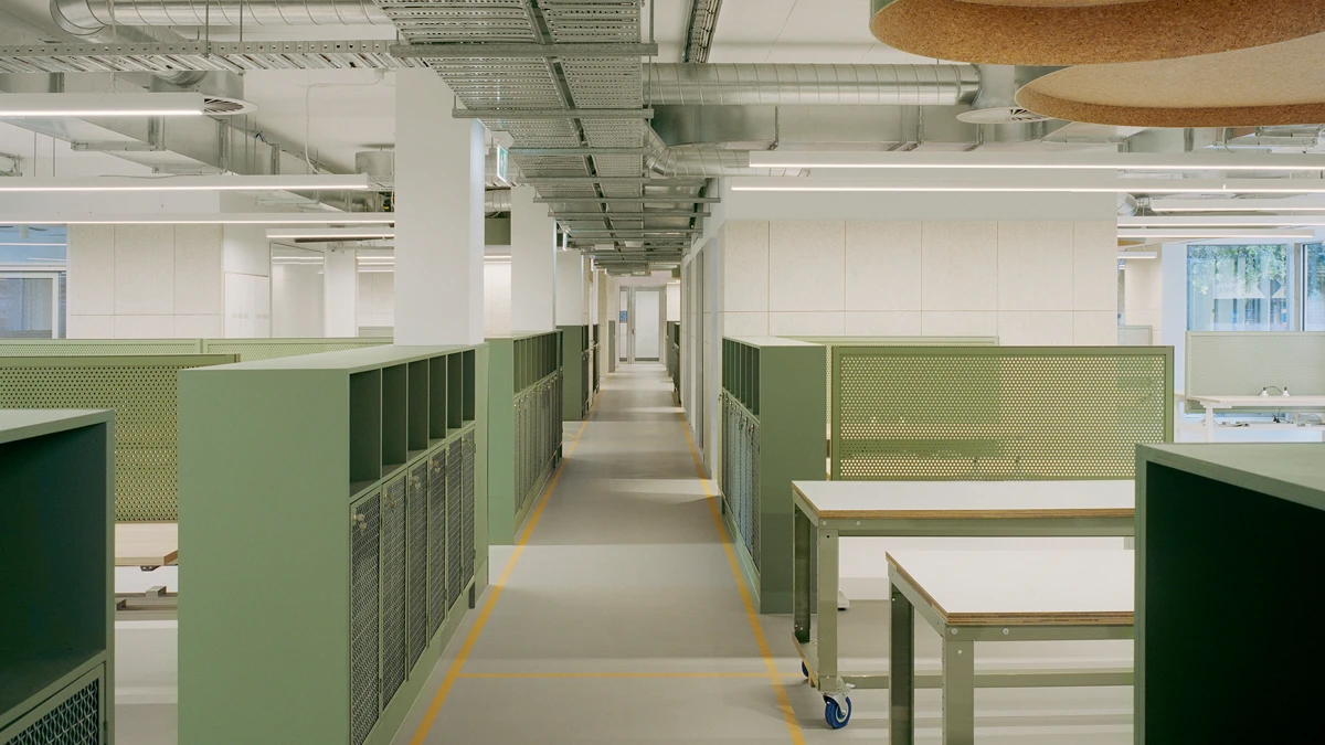 Inside of lab building with tables and storage lockers.