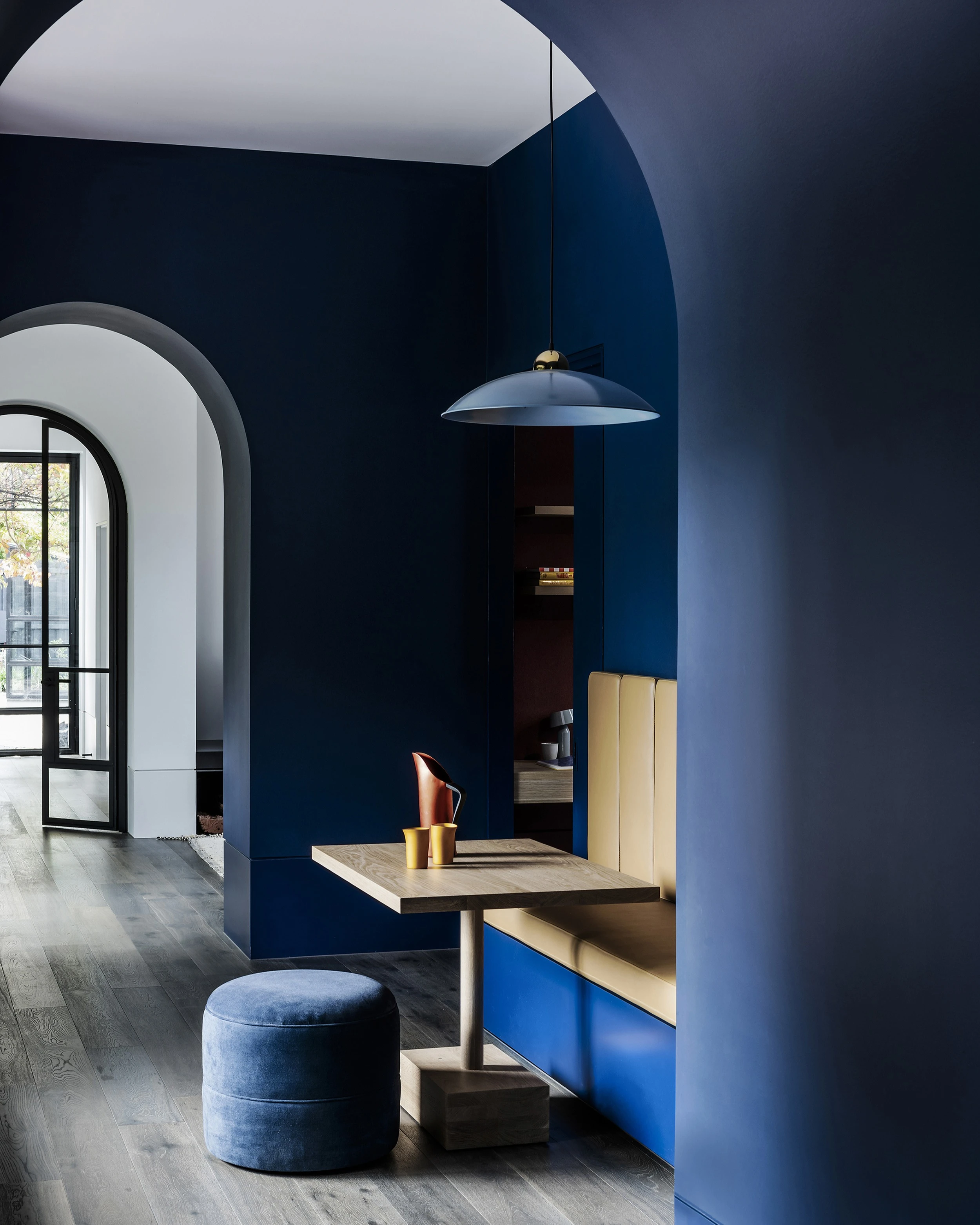 Small blue dining area with archways leading through house