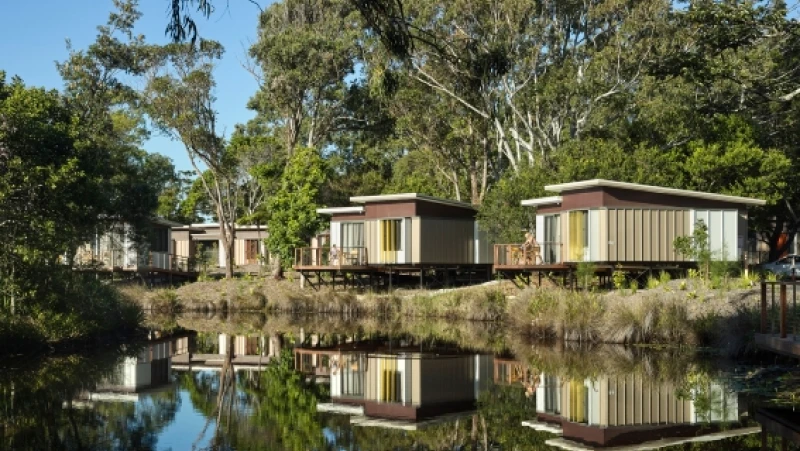 Several brown and white cabins facing water