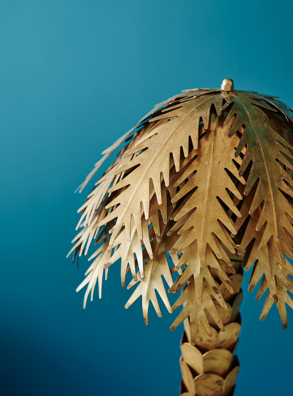 Gold metal palm tree front of a blue wall in Dulux Bondi. Dulux Colour Trends 2018 – Escapade Palette. 