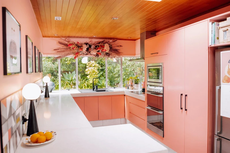 Wide angle of Evie Kemp's pink kitchen painted in Dulux Big Glory Bay and Bluff Hill