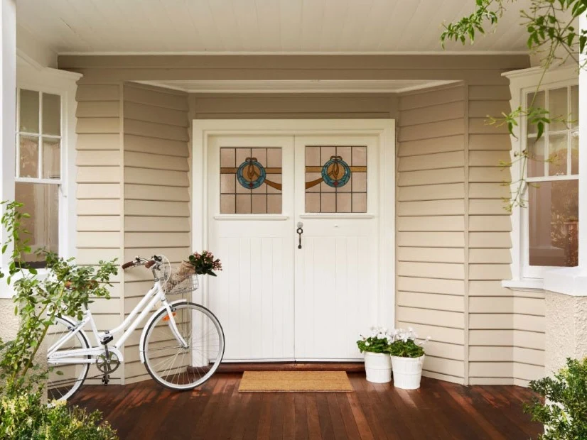 A house with weatherboards and white double wooden doors