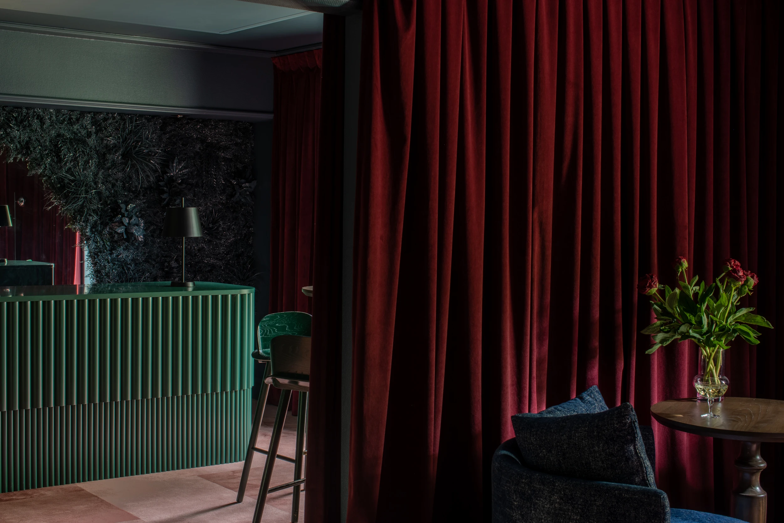 Dark green desk and maroon velvet curtains