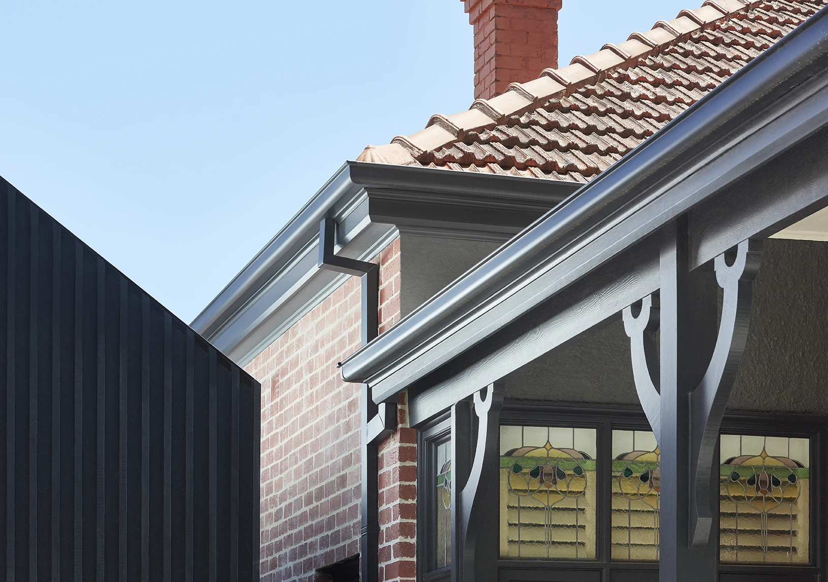 Red brick home with grey guttering and trim