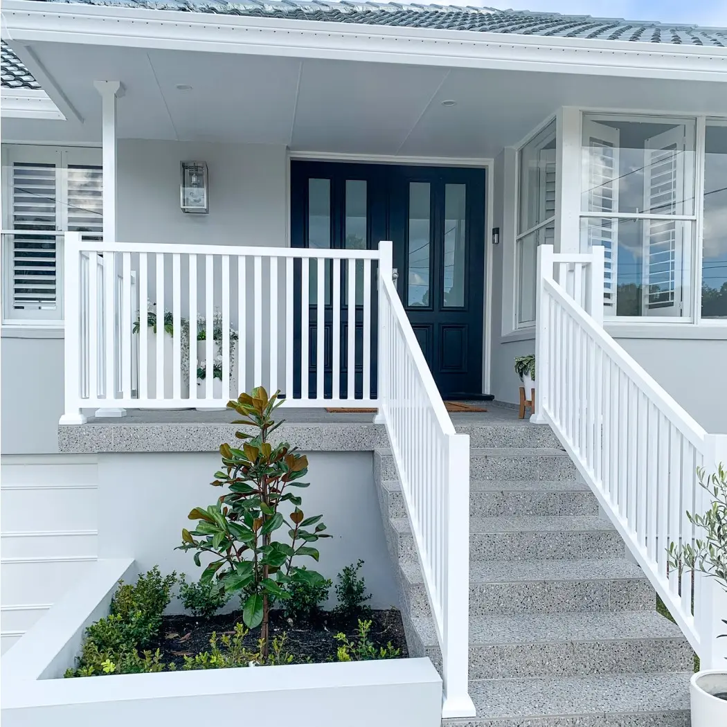 Exterior of white and grey Hamptons-style house with steps to front entry and patio