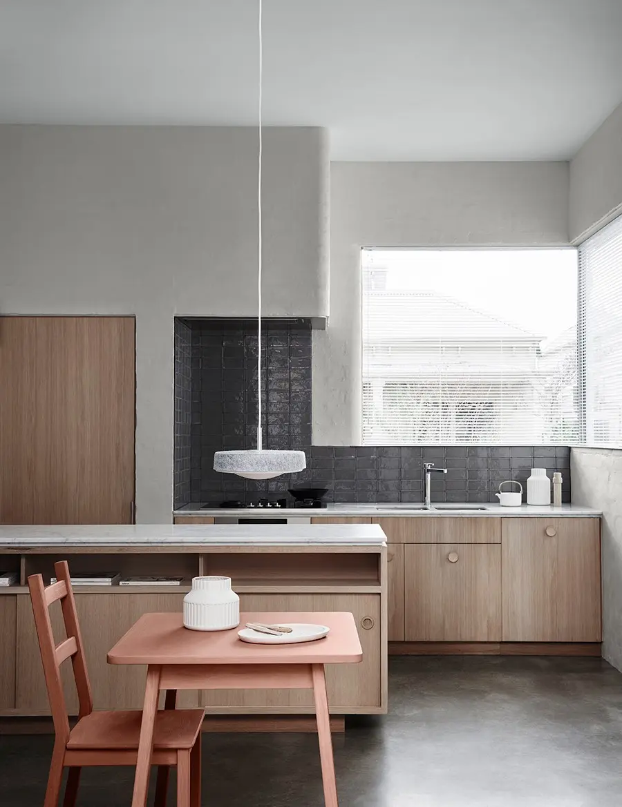 Minimalist grey kitchen with clay coloured table and chairs