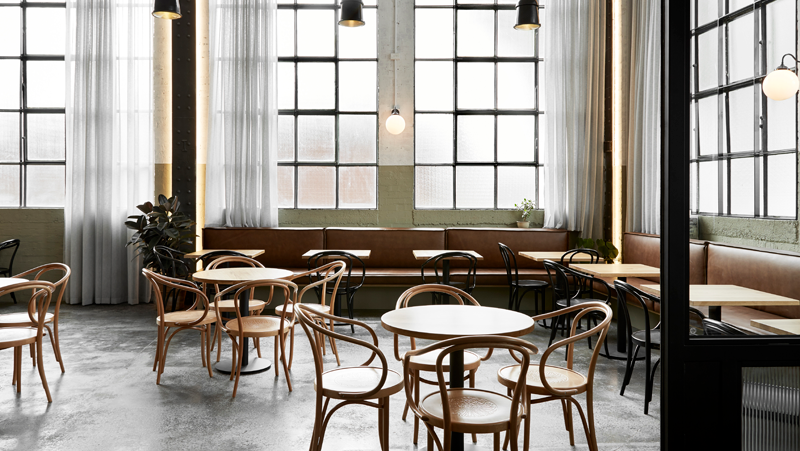 interior dining setting, with wooden chairs and large windows.