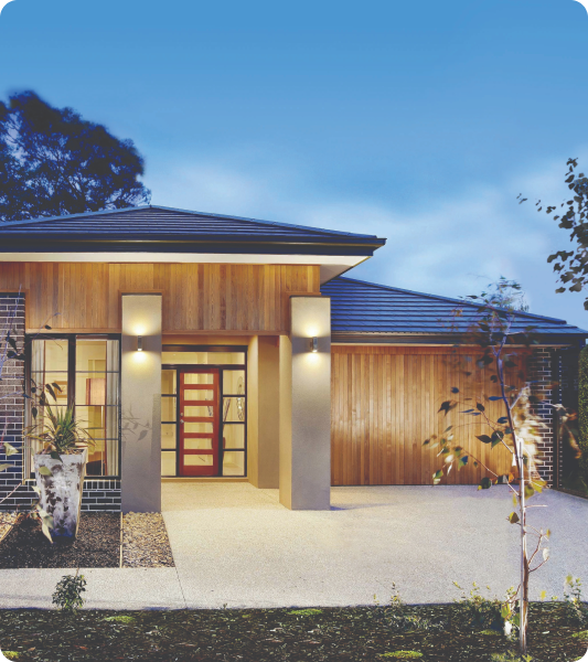 Exterior of home it sunset with lighting featuring Dulux Avista concrete driveway