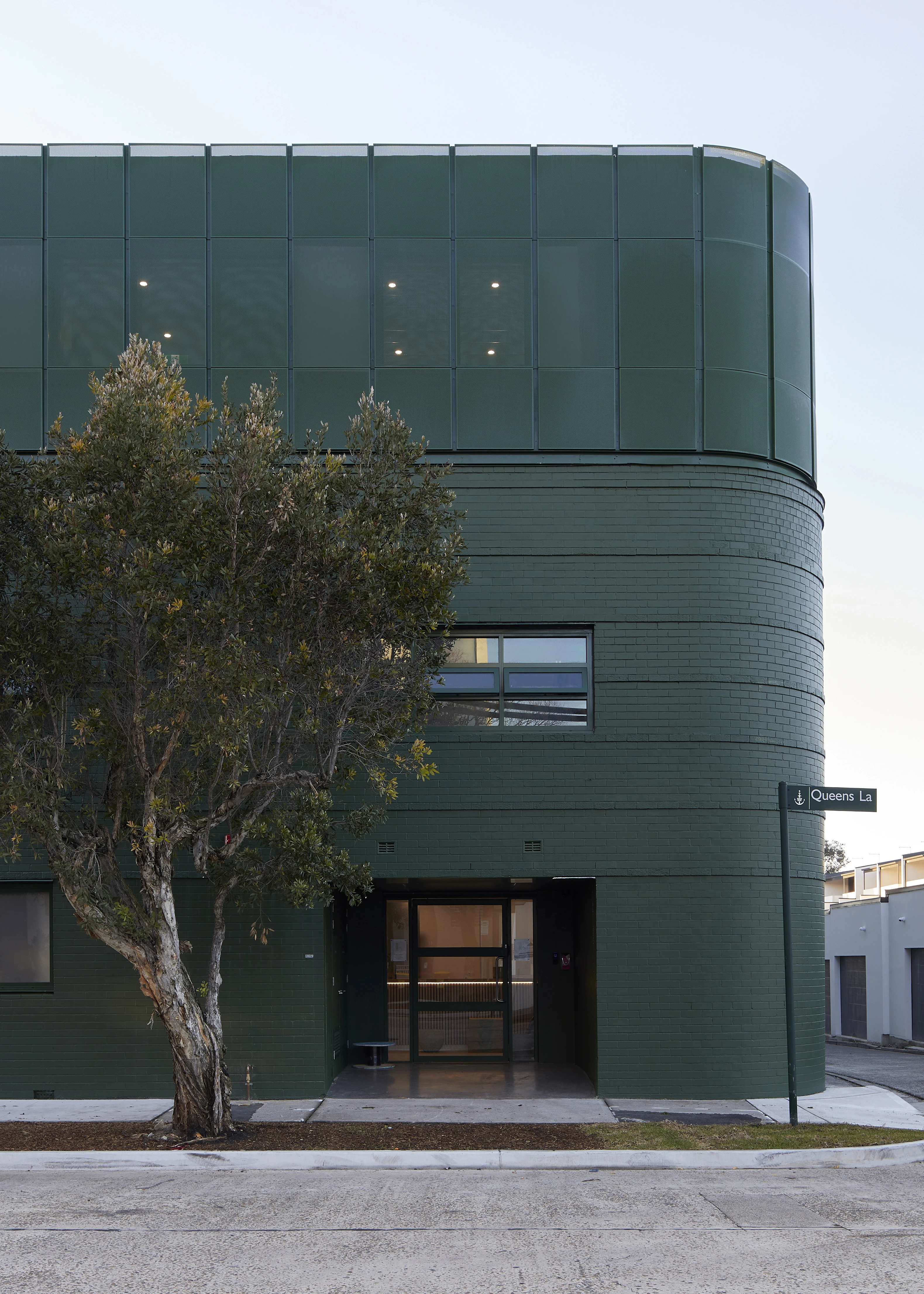 Exterior of dark green three-storey corner building.