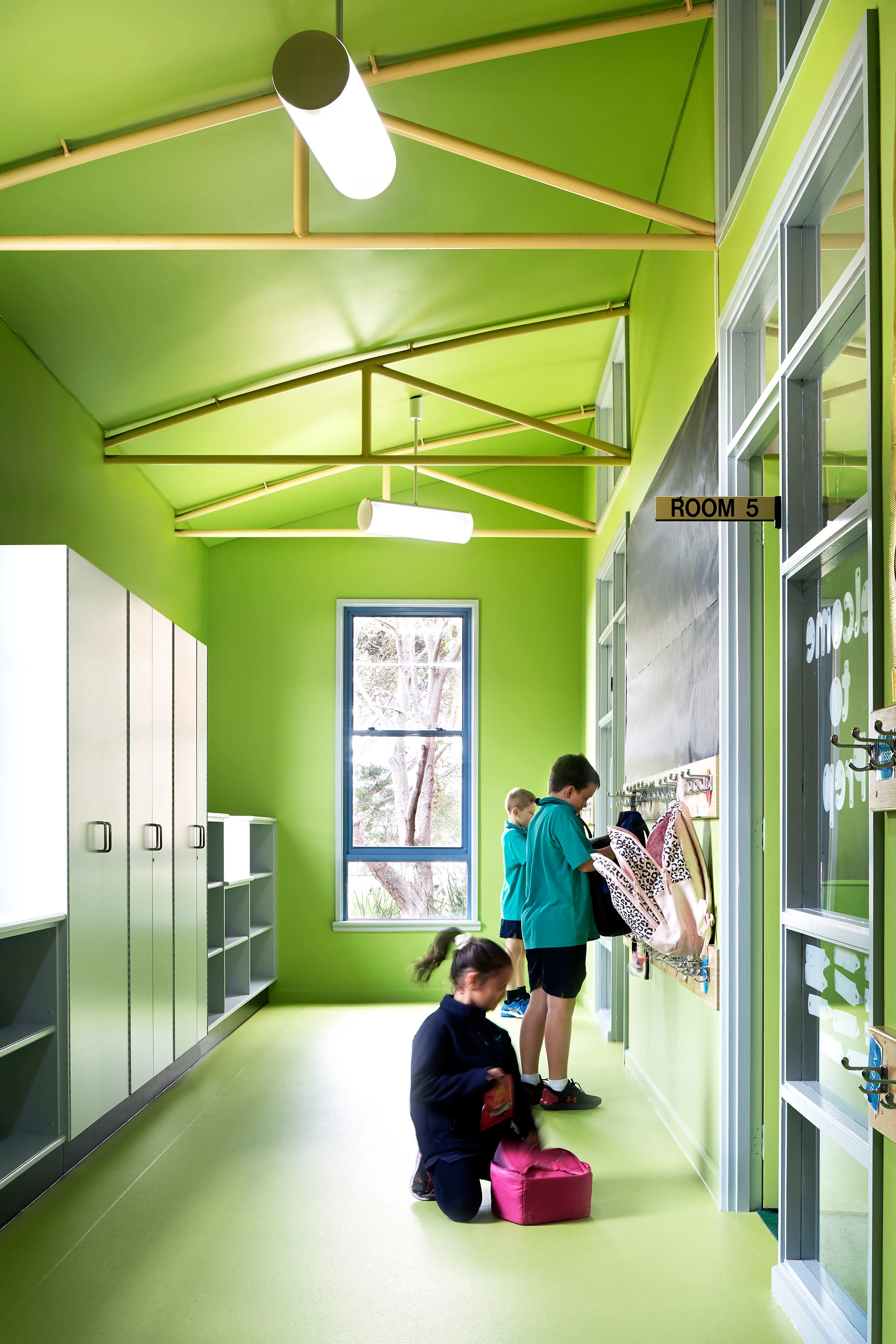 Green school hallway with storage and lockers