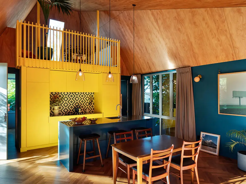 house with yellow wall behind island kitchen counter bench