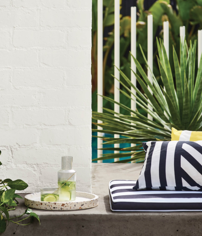 Exterior white painted brick with striped cushions