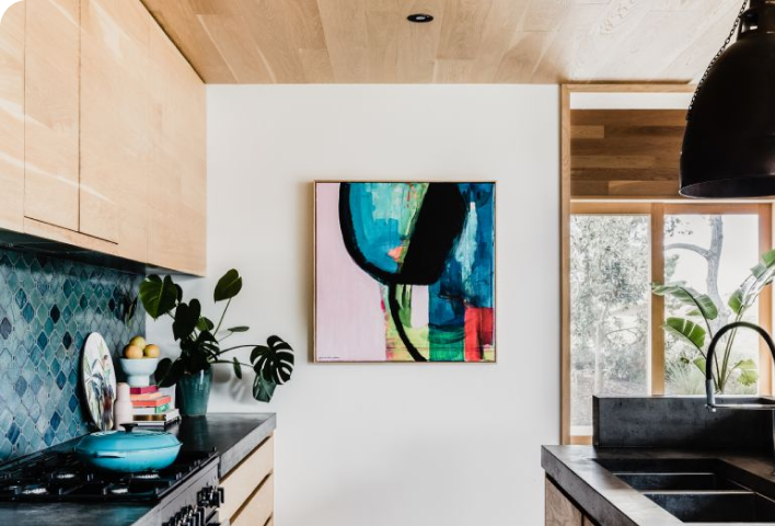 Kitchen with timber cabinets, white wall and colourful artwork