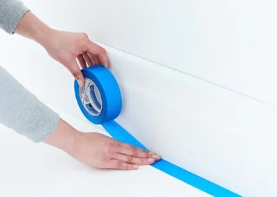 Painters tape being used to prepare a room.