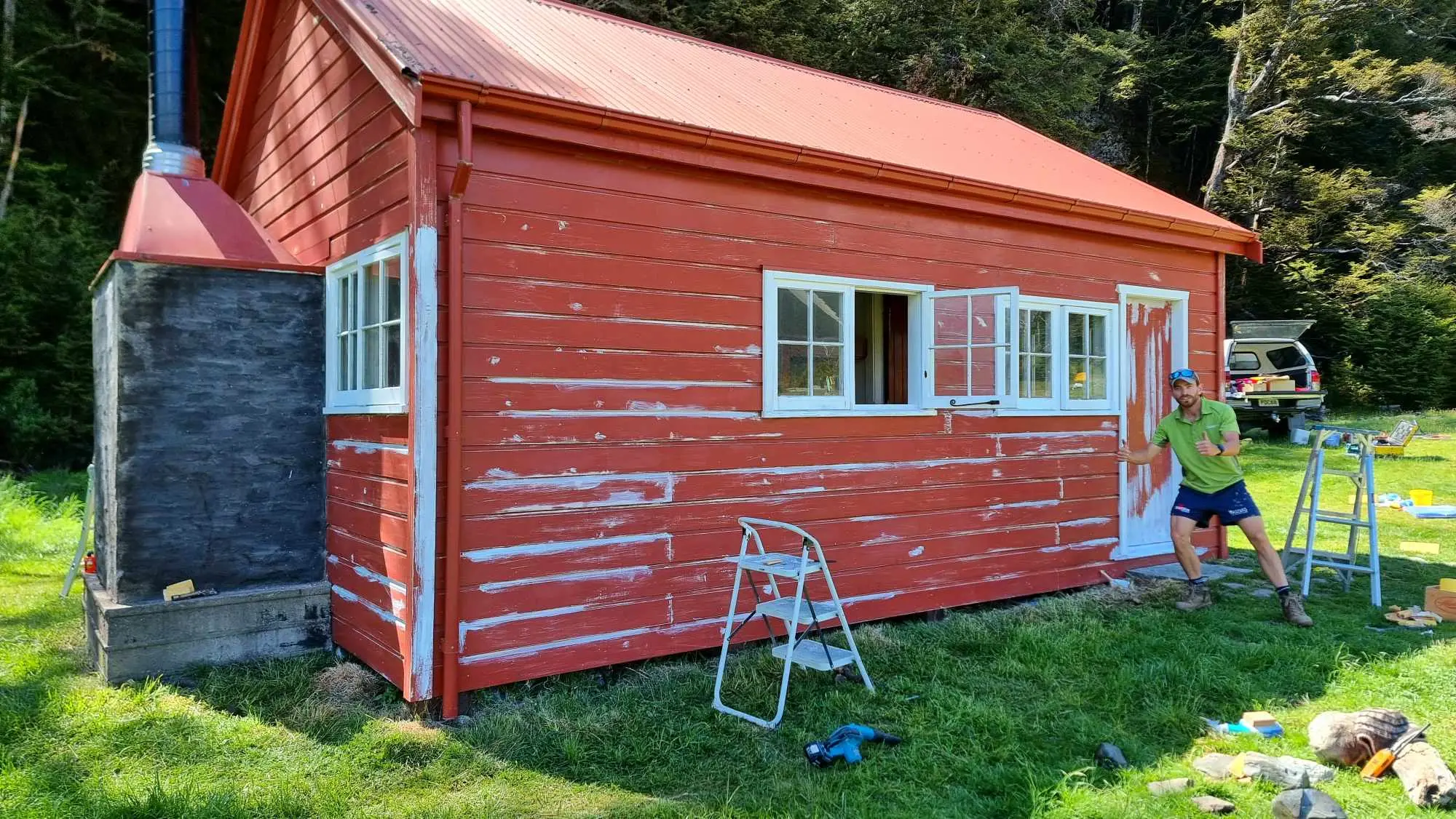 A painter painting the Ruataniwha Red Hut