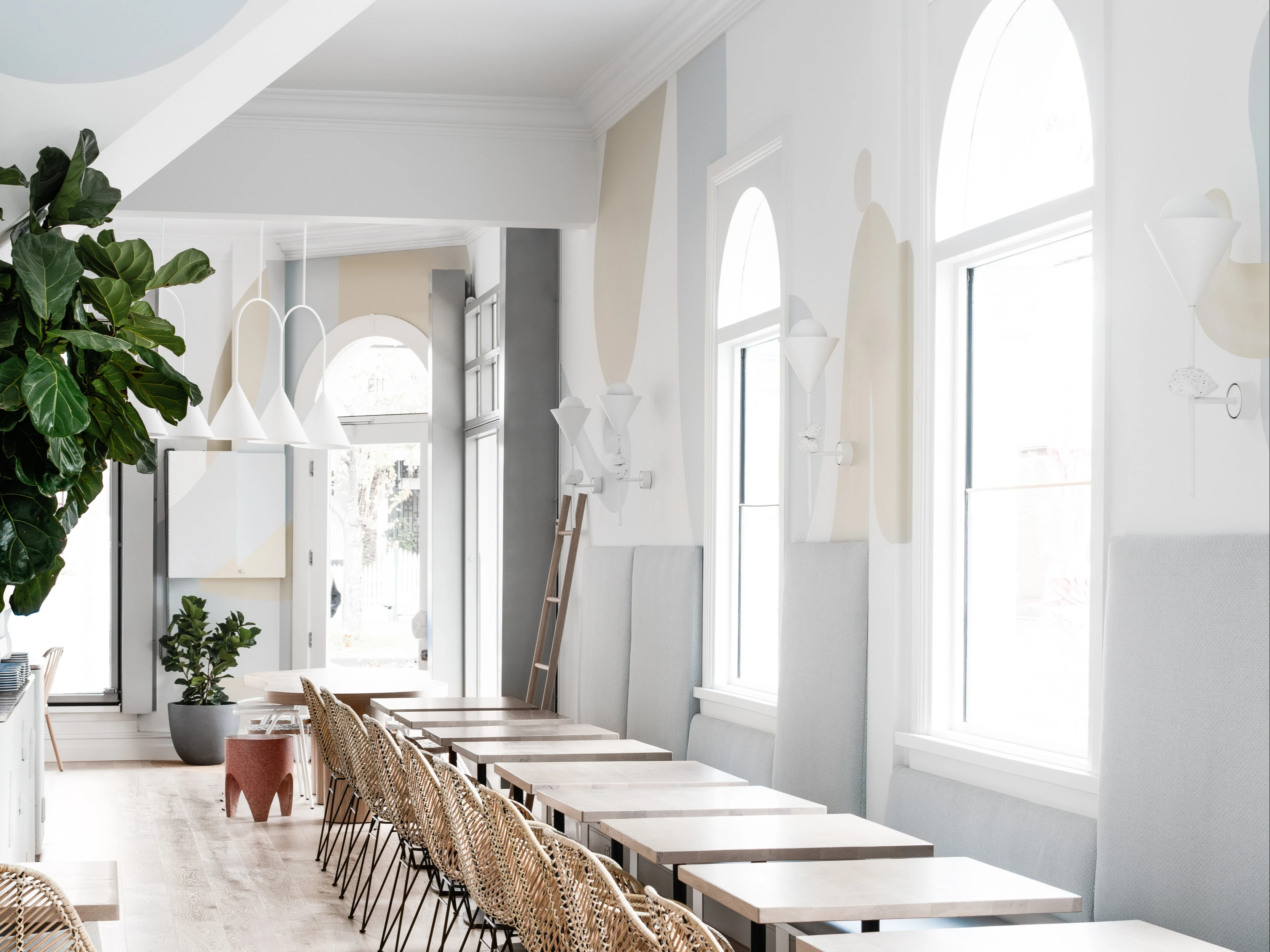 white and grey cafe with timber tables and arched windows