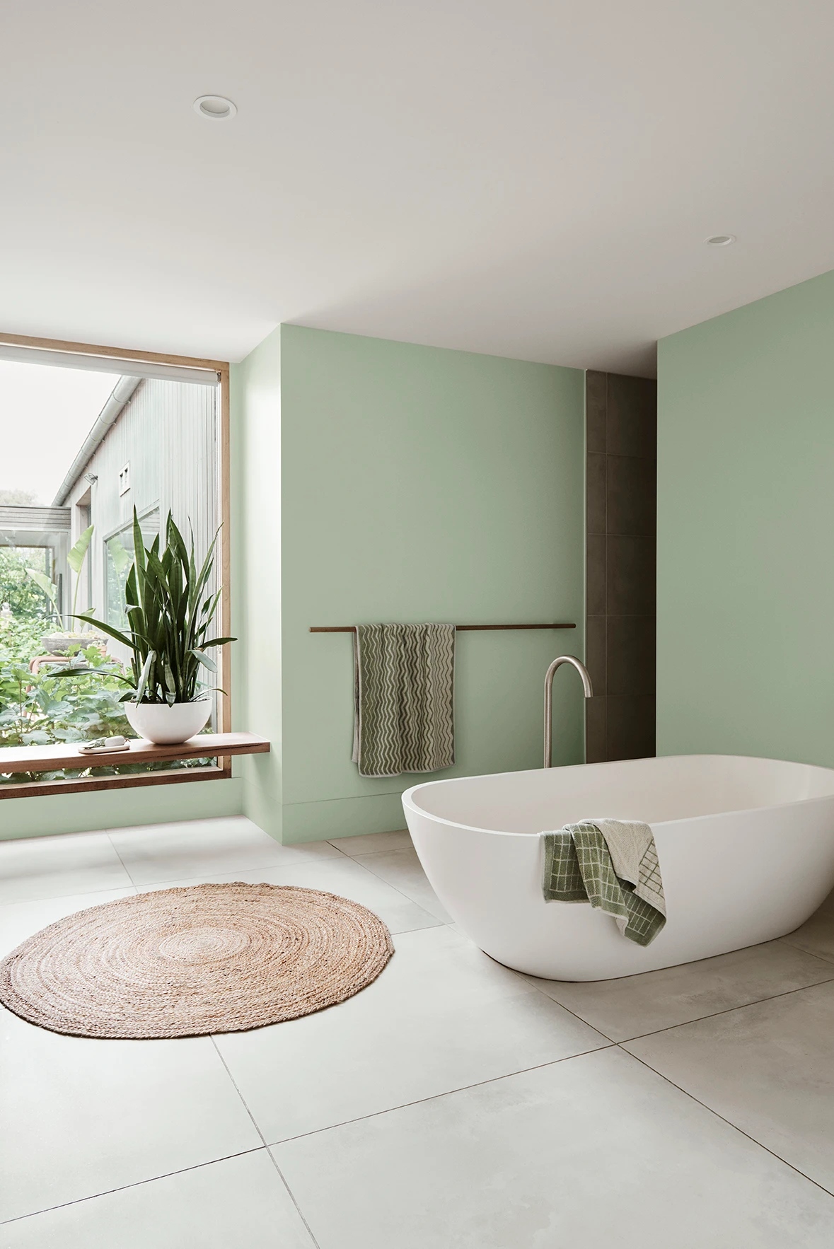 Bathroom with stand alone bath, tiled floor and green walls