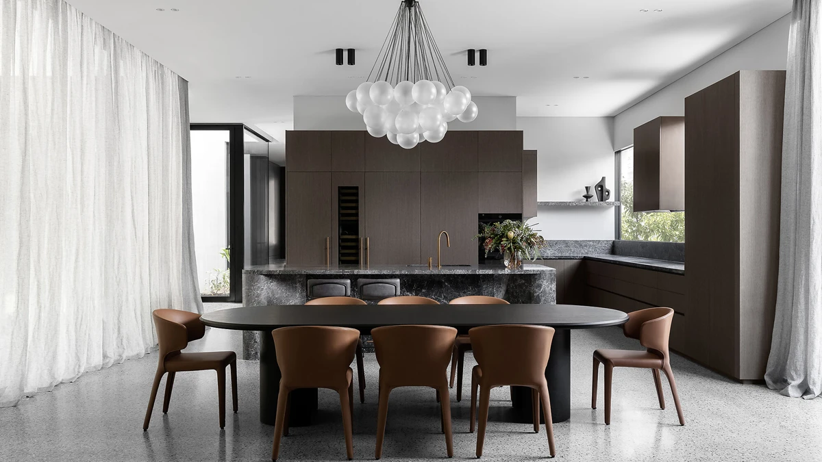 Open-plan kitchen and dining area with floor to ceiling curtains at side windows.