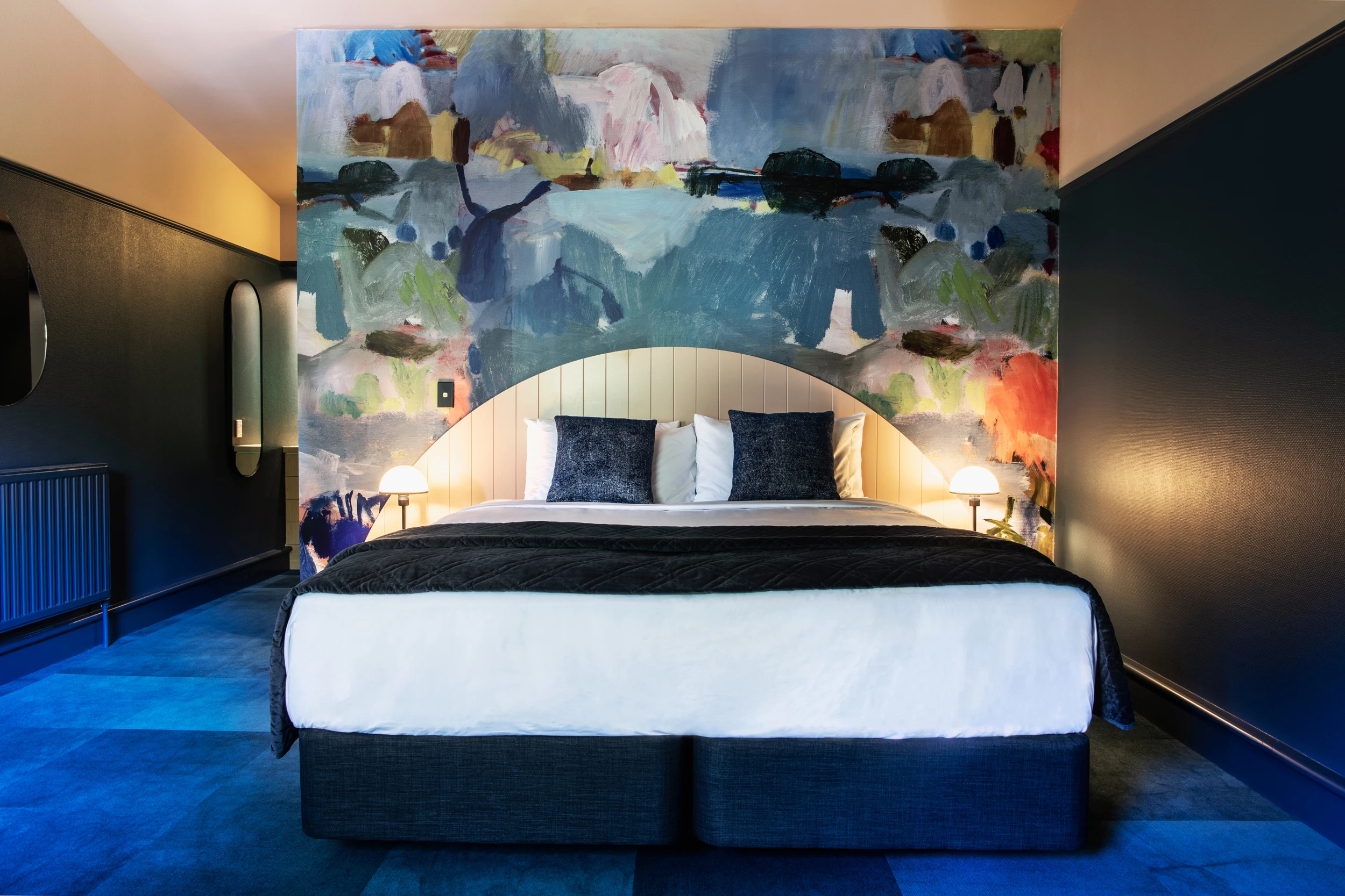 Hotel bed with multicoloured feature wall