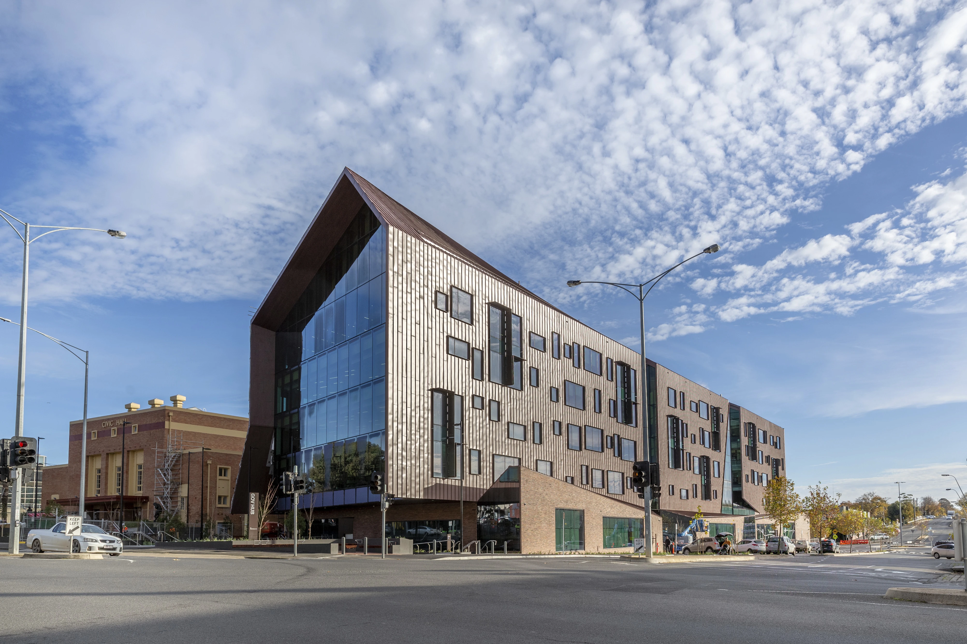 Exterior multi-storey building, asymmetrical pitched roof and irregular size of rectangle and square windows.