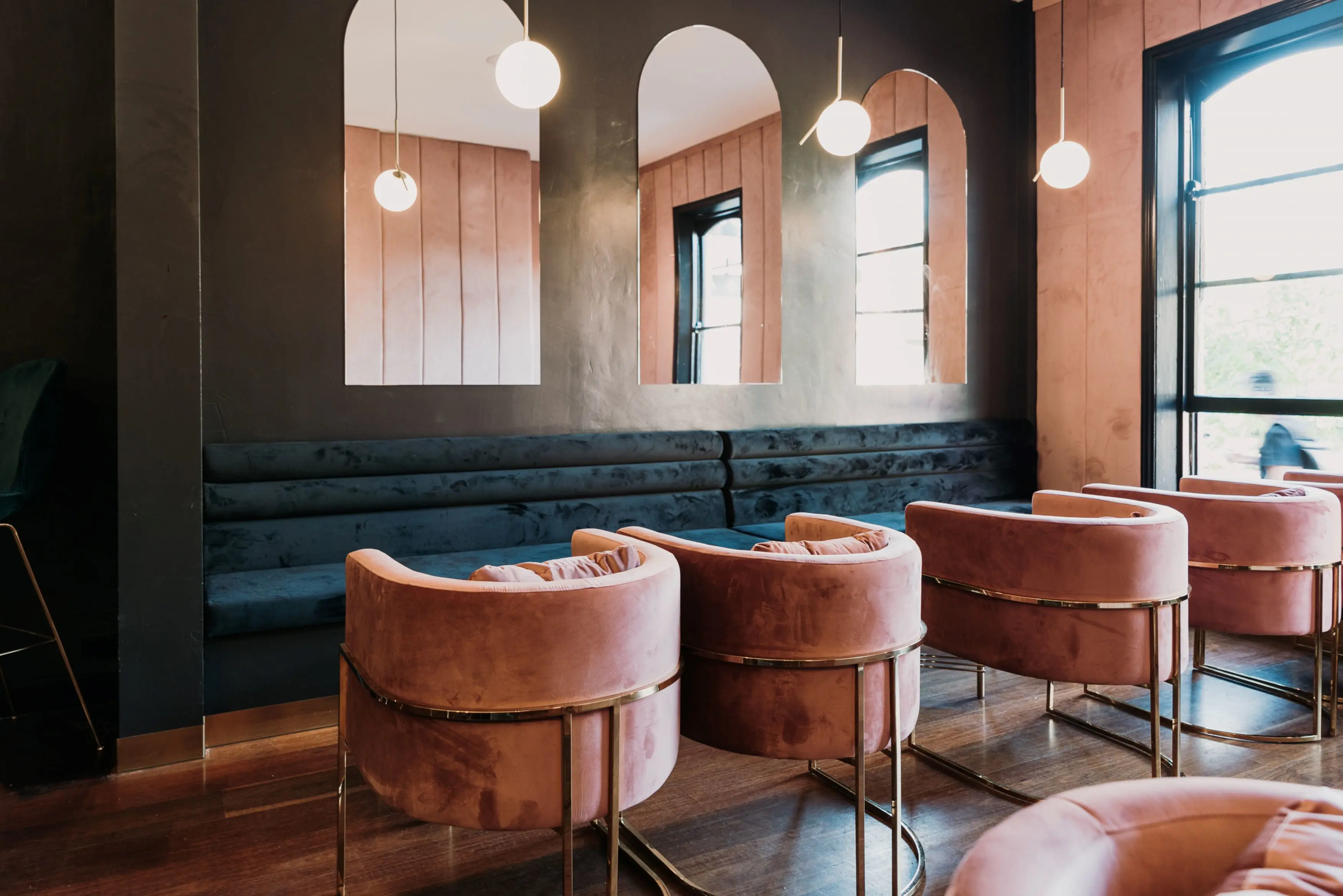 Plush seating area with dark velvet bench seat and dusty rose tub chairs