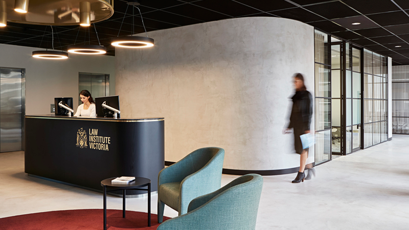 Curved grey reception area with black desk.