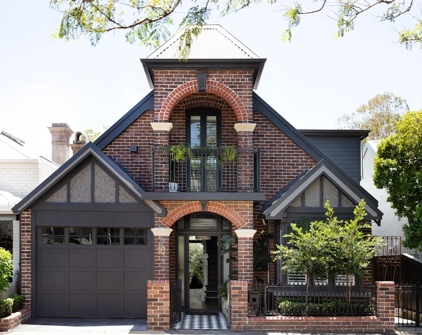 Double-storey red brick federation-style house with black trim