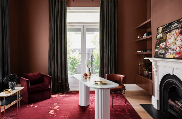 Brown living room with velvet furniture, white mantlepiece over fireplace, white modern desk