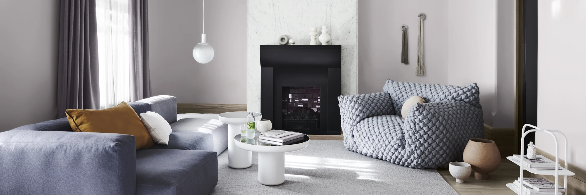 interior lounge room with grey couches and fireplace. 