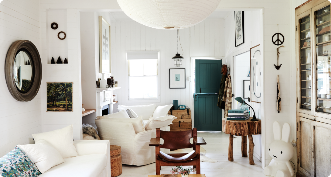 White living room with white couches and deep green Dutch door