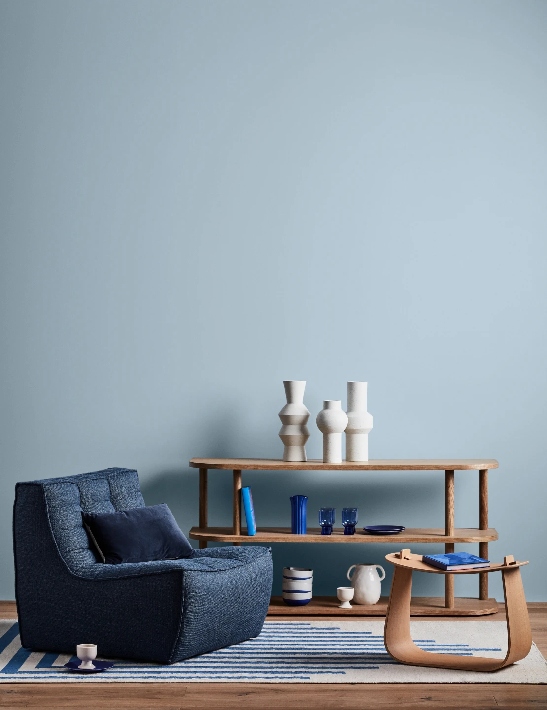 Living room with Pre School coloured wall, blue sofa and light timber furnishings