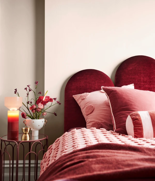 Maroon velvet bedhead with plush linens 