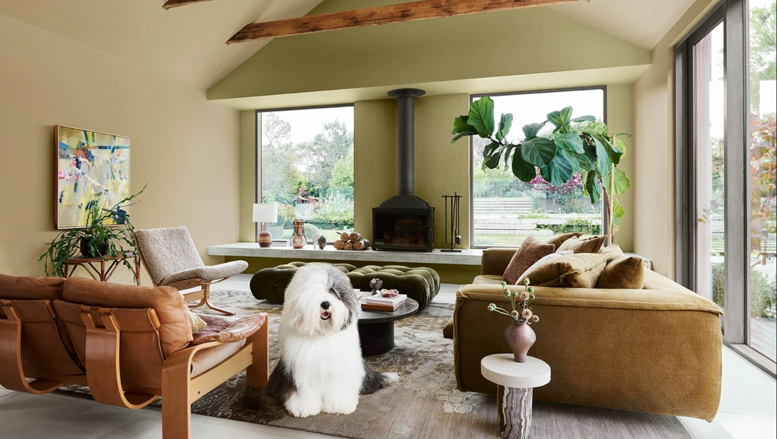 Dulux dog in a neutral, earthy living space featuring a velvet leather lounge and fireplace.