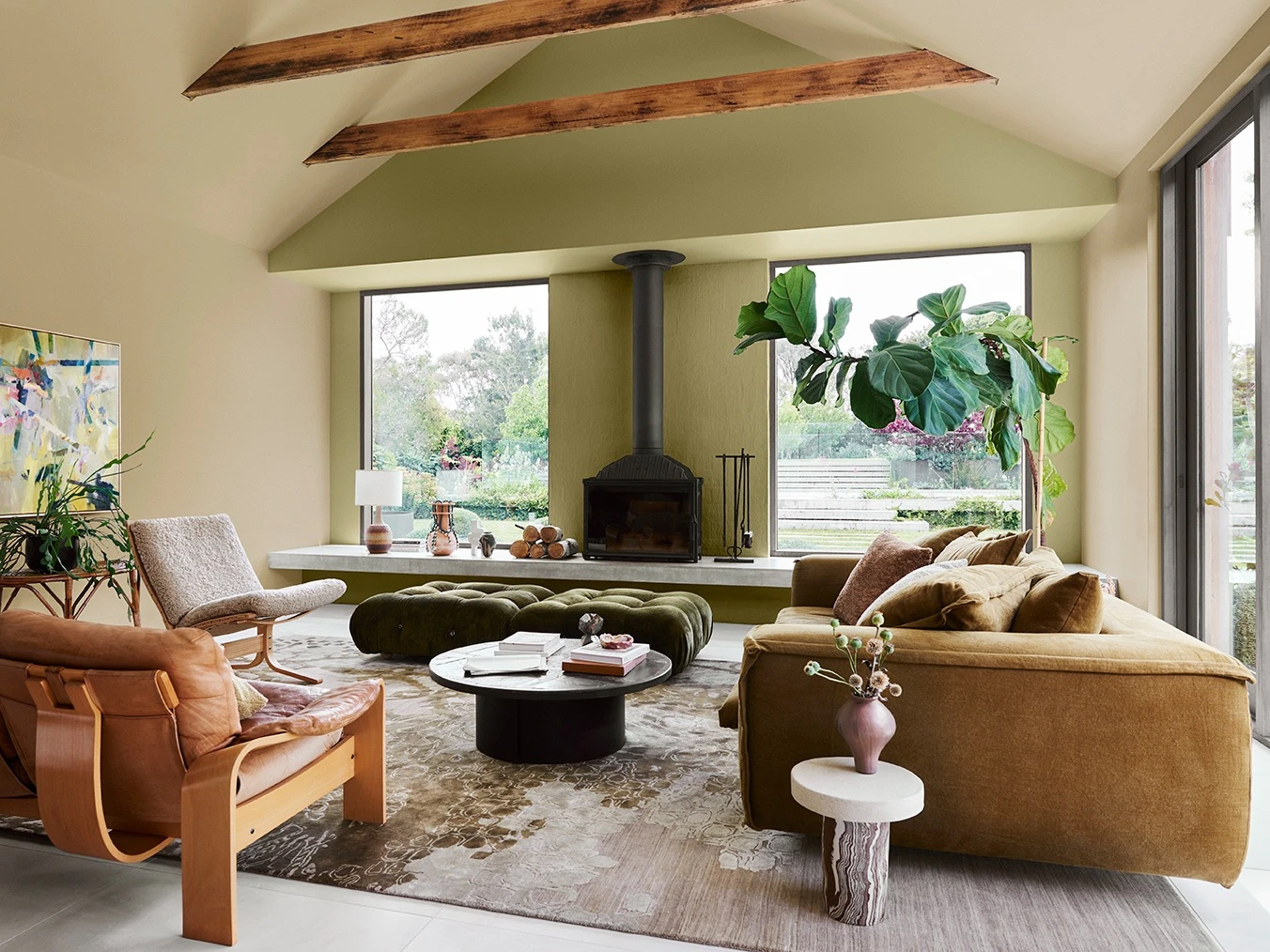 Cosy interior living room with soft green walls, fireplace and timber beams