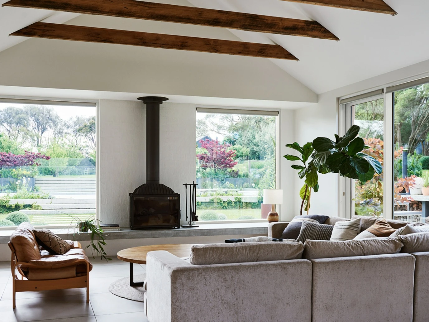 Interior living room with white walls, fireplace and timber ceiling beams