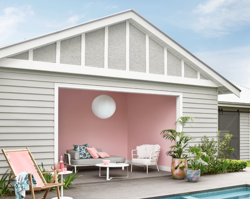 Pool house with Pink Dust coloured interior walls, Tranquil Retreat coloured weatherboards and Snowy Mountains Half trims. Area is decorated with lounge furniture and greenery. 